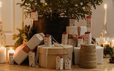 Paquets cadeaux et bougie au pied d'un sapin.